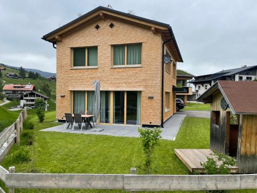 a house with a patio and a table in the yard at Chalet Alpenluft in Hirschegg