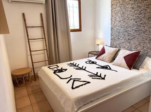 1 dormitorio con 1 cama con manta blanca en Le Cocon Bord de mer, en Belgodère