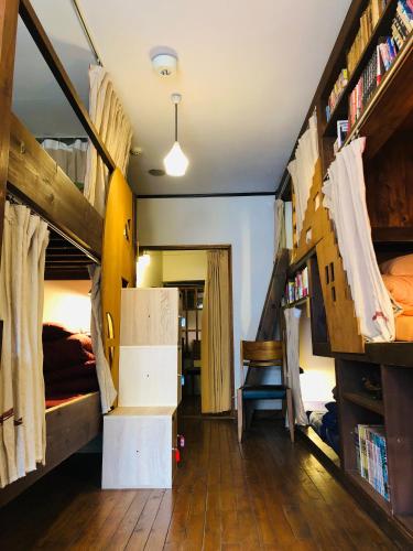 a room with two bunk beds and a desk at Onomichi Guest House Anago-no-Nedoko in Onomichi