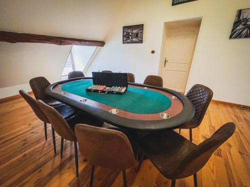 a poker table with chairs and a laptop on top at Villa festive HOMAZING piscine privée 1h de Paris in Chantecoq