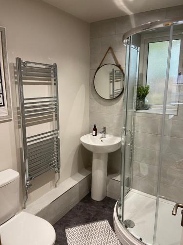 La salle de bains est pourvue d'une douche, d'un lavabo et de toilettes. dans l'établissement Calderside Cottage (2 BDR Central Hebden Bridge), à Hebden Bridge