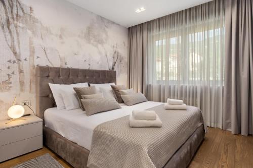 a bedroom with two beds and a large window at Luxury Apartment Iris Adriatica ***** in Opatija