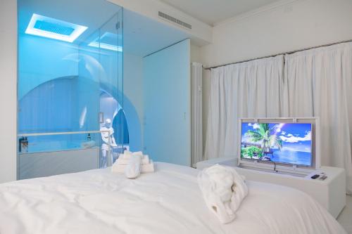 a bedroom with a white bed and a tv at Sant'Agnese DOMUS in Milan