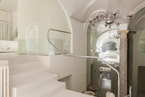 a staircase in a house with a chandelier at Sant'Agnese DOMUS in Milan