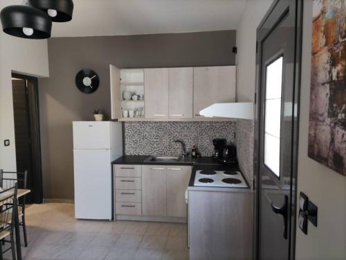 a kitchen with a white refrigerator and a stove at Music Reflections Apartment near Nafplio in Néa Kíos