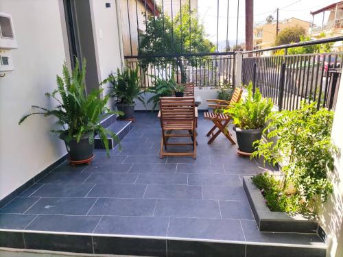 a patio with chairs and plants on a balcony at Music Reflections Apartment near Nafplio in Néa Kíos