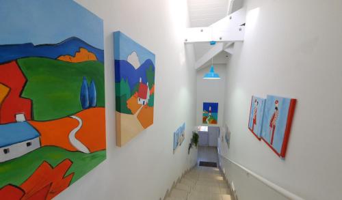 a hallway with colorful paintings on the walls at LekkeBly Boutique Loft in Paternoster