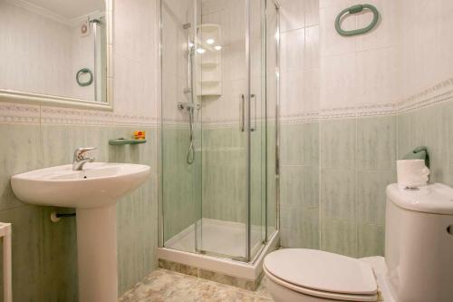 y baño con ducha, aseo y lavamanos. en Apartamentos Alan, en Nerja
