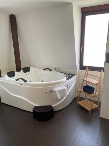 uma banheira branca na casa de banho com uma cadeira em Ferienwohnung Baars em Bad Sachsa