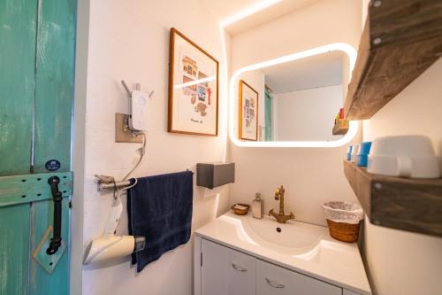 ein Bad mit einem Waschbecken und einem Spiegel in der Unterkunft Ichi The Hostel in Minamicho