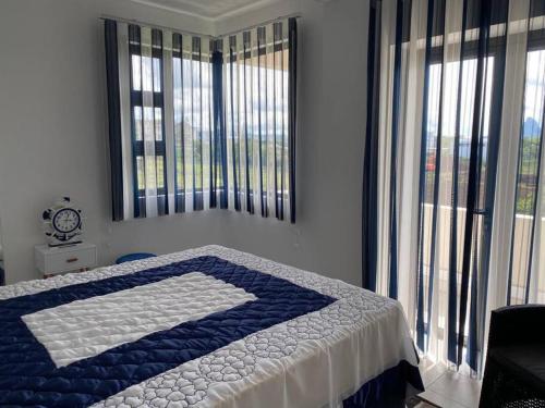 a bedroom with a blue and white bed with large windows at Stylish & Luxury 2-bed parkside apart with pool in Phoenix