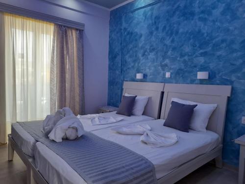 a bedroom with two beds with blue walls at Villa Bel Passo Apartments in Kefalos