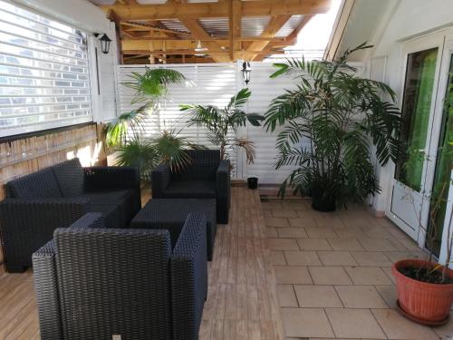 a patio with couches and potted plants on it at SAS L' Ilot Vert in La Saline les Bains