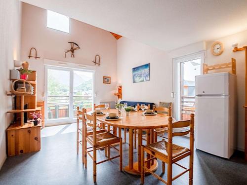 une cuisine avec une table, des chaises et un réfrigérateur dans l'établissement Duplex 8 Pers à Saint Lary Village - Balcon Sud, Proche Commodités et Activités Montagne - FR-1-296-306, à Saint-Lary-Soulan
