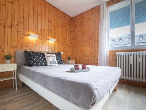 - une chambre avec un grand lit et des murs en bois dans l'établissement Appartement T3 pour 8 personnes avec balcon, parking privé et sud - Saint-Lary Centre - FR-1-296-323, à Saint-Lary-Soulan