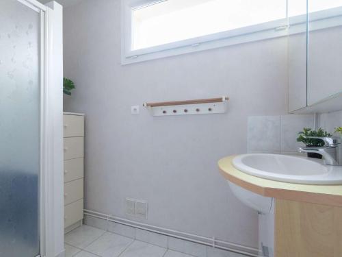 une salle de bain blanche avec un lavabo et un miroir dans l'établissement Appartement T3 pour 8 personnes avec balcon, parking privé et sud - Saint-Lary Centre - FR-1-296-323, à Saint-Lary-Soulan