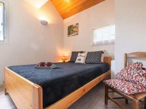 une chambre avec un lit et une chaise dans l'établissement Duplex ensoleillé pour 6 personnes avec balcon et parking à Saint-Lary village - FR-1-296-188, à Saint-Lary-Soulan