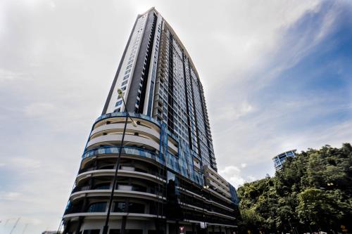 a tall building with glass windows on the side of it at Jesselton Quay by Pinstay in Kota Kinabalu