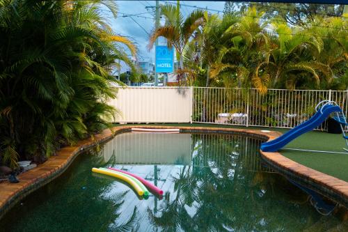a swimming pool with a slide and a playground at Kennedy Drive Boutique Motel - Close To City Centre & Airport in Tweed Heads