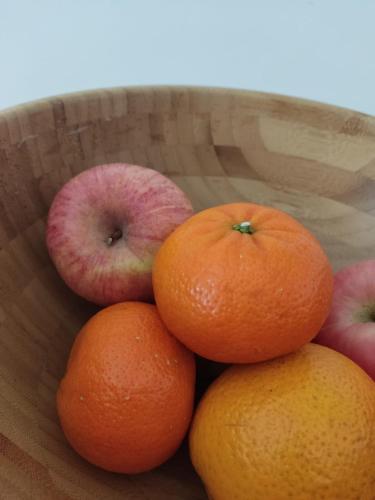 a bowl of fruit with oranges and apples at Studio in the heart of Sports City -great view & amenities! in Dubai