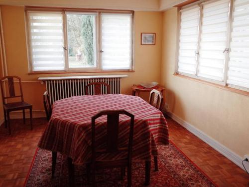 a room with a table and two chairs and windows at Maison de Jeanne in Eschau