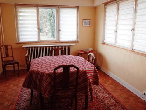 EschauにあるMaison de Jeanneのテーブルと椅子2脚、窓が備わる客室です。