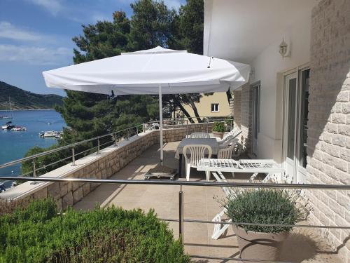 a patio with an umbrella and a table and chairs at Apartment Portofino in Primošten