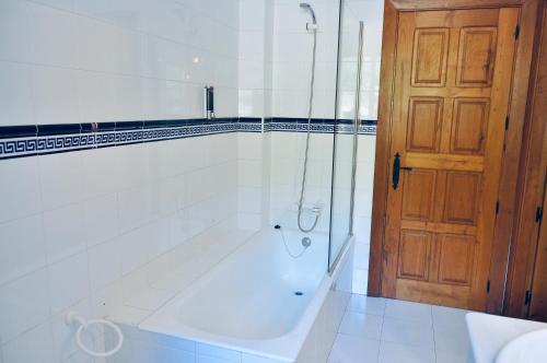 a bathroom with a tub and a glass door at Caserio Kamirune in Laukiz