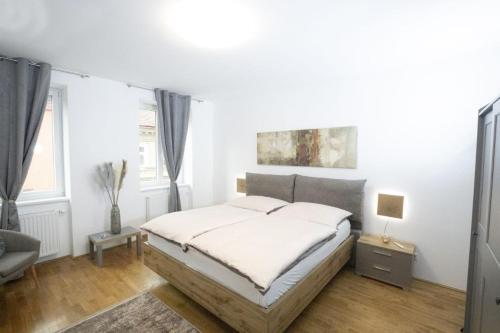 biała sypialnia z łóżkiem i kanapą w obiekcie Stadtjuwel l BG10 w Wiedniu