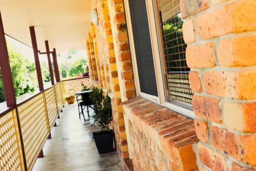 a brick wall with a window on a balcony at Kennedy Drive Boutique Motel - Close To City Centre & Airport in Tweed Heads