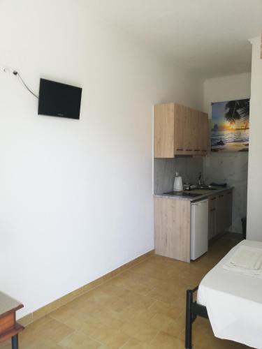 a white room with a kitchen and a bed at Anestis Studios in Agios Georgios