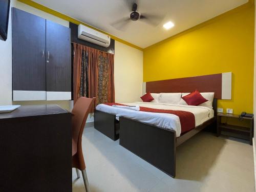 a hotel room with a bed and a desk and a room at Skyry Hotels Adyar in Chennai