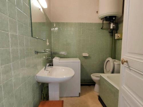 une salle de bain avec un lavabo, des toilettes et un miroir dans l'établissement Appartement 2 pièces central à Cauterets avec balcon, parking et proximité Citycab - FR-1-234-145, à Cauterets