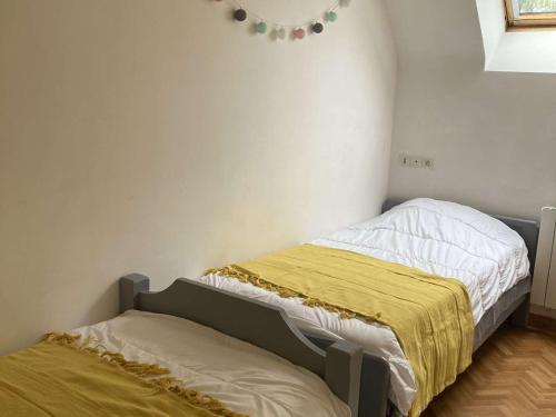 - une chambre avec 2 lits jumeaux et des draps jaunes dans l'établissement Villa plain-pied avec piscine privée, jardin et WIFI - Proche Trégastel et Perros-Guirec - FR-1-368-86, à Pleumeur-Bodou