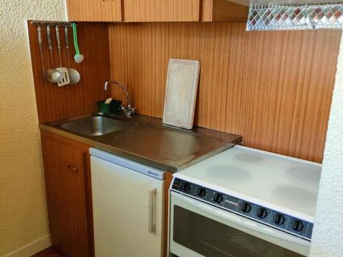 une petite cuisine avec un évier et une cuisinière dans l'établissement Charmant 2 Pièces 4/6 Pers Centre Ville, Balcon, Cuisine Équipée, Parking - FR-1-234-130, à Cauterets