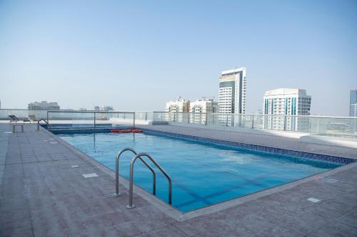 a swimming pool on the roof of a building at Studio in the heart of Sports City -great view & amenities! in Dubai