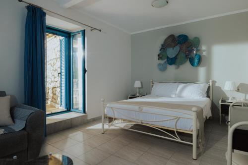 a white bedroom with a bed and a window at Sea Mansion Lefkada in Nikiana