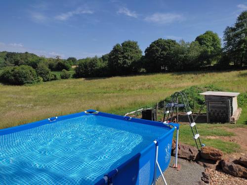 a swimming pool in a field with a playground at Chambre d'hôtes pour les 24 heures du Mans in La Bazoge