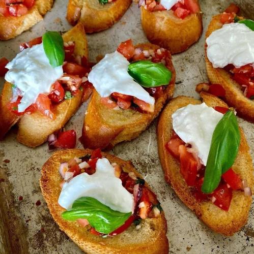 a group of small pizzas with tomatoes and sour cream at Ideal House in Parga