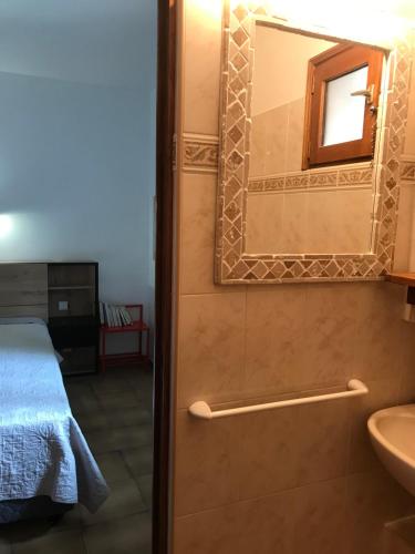 a bathroom with a bed and a sink and a mirror at Appartement 3 pièces et jardin in Collioure