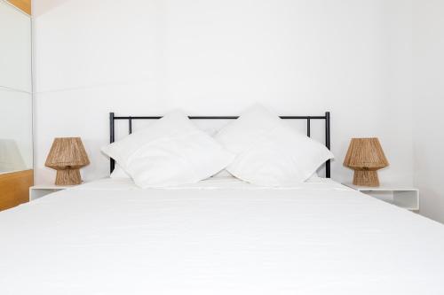 a white bed with two white pillows on it at Le Hameau in La Croix-Valmer