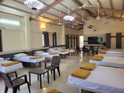 a room with many tables and chairs and a room with at Cocorico Beach Resort in Dapoli