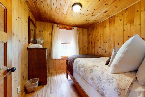 a bedroom with a bed in a wooden cabin at Lake House Retreat in Ossipee
