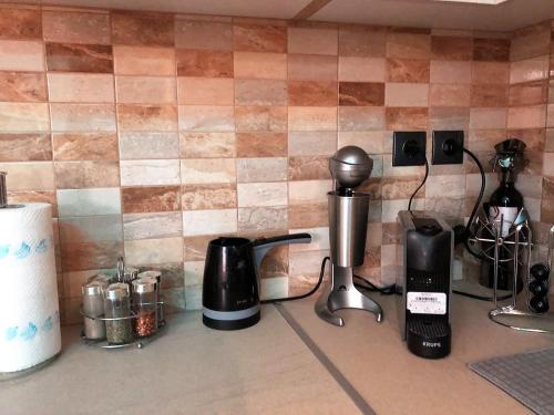 a kitchen counter with various appliances on a tile wall at Renovated flat with huge balcony - Ανακαινισμένο διαμέρισμα με τεράστιο μπαλκόνι in Karditsa