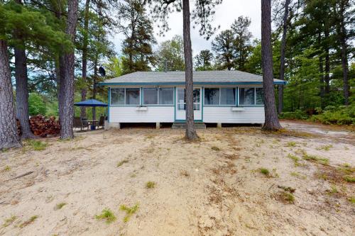 a blue and white house in the woods at Lake House Retreat in Ossipee