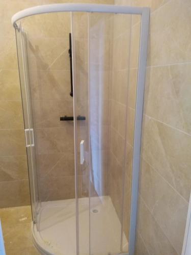 une douche avec une porte vitrée dans une salle de bain dans l'établissement La tanière, à Champs Sur Tarentaine