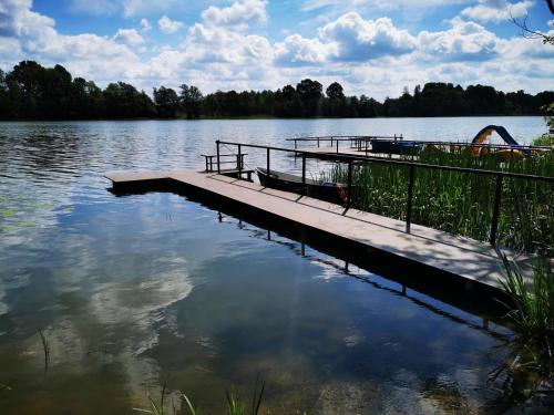 a dock on a body of water at Urocza Przystan in Kiemiany