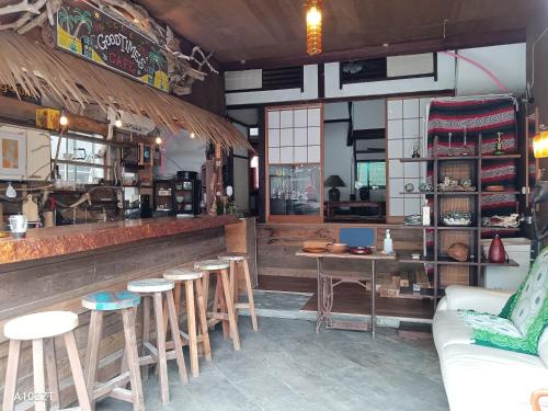 un restaurante con un bar con mesas y sillas en 下田市旧南豆, en Shimoda