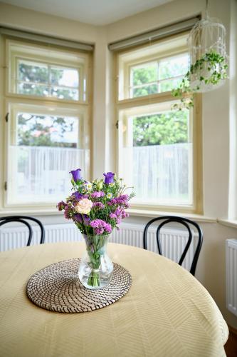 a vase of purple flowers sitting on a table at Vila Betula in Nové Město na Moravě