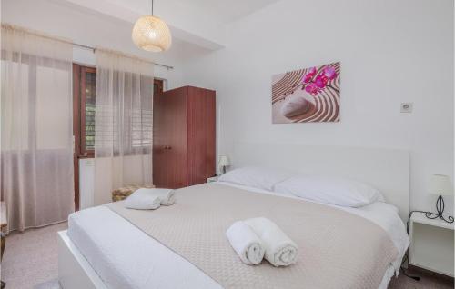 a bedroom with a white bed with towels on it at Stunning Apartment In Bascanska Draga With Kitchen in Draga Bašćanska